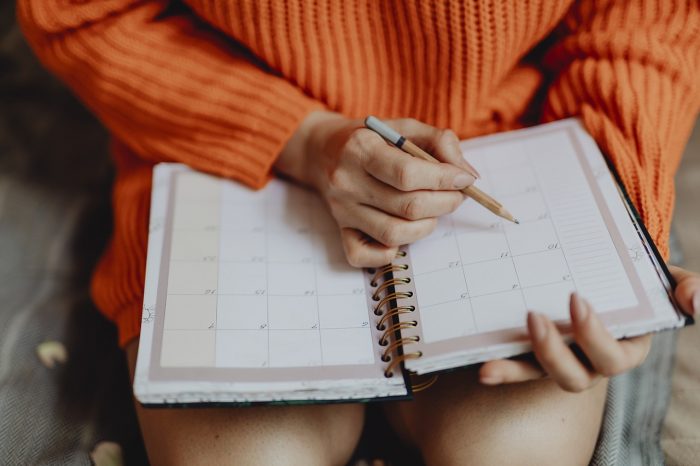 Image of a woman with a calendar on her lap. A calendar is a great place to find content ideas.