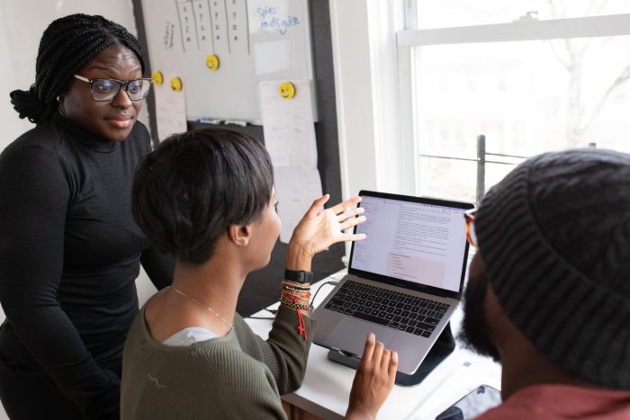 7) Photo of three people in an editorial meeting talking about SEO