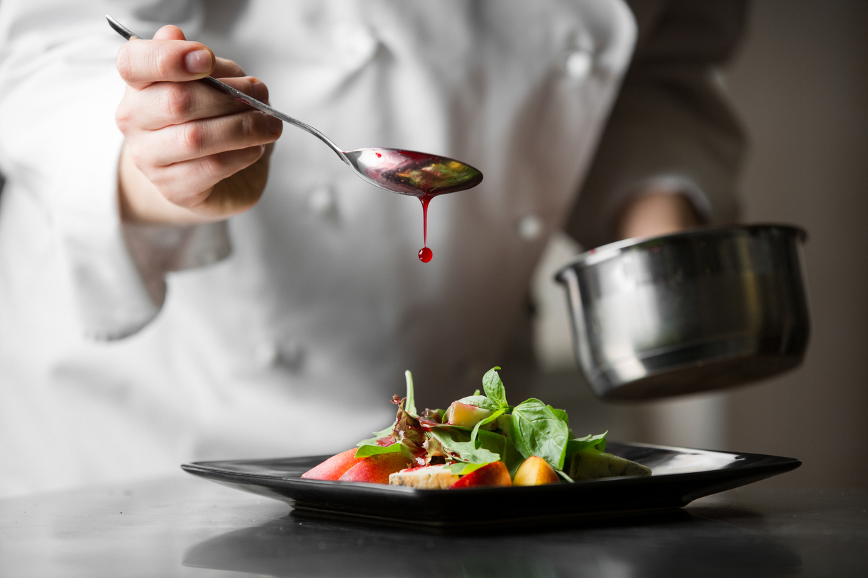 A chef applies the jus to a dish before serving, symbolising Typeset's menu proofreading service.