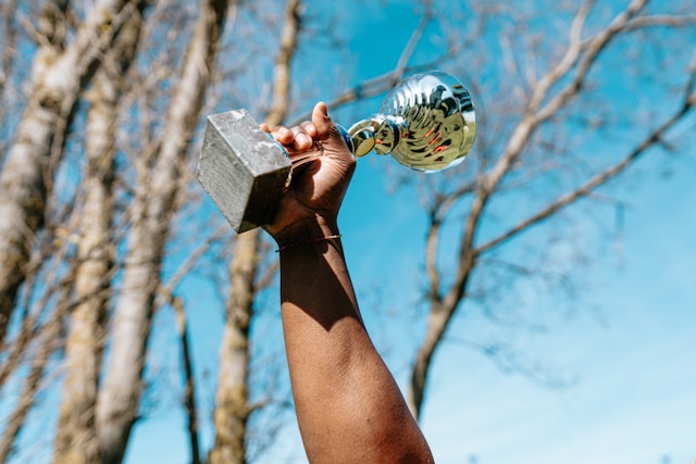 A hand holding a trophy aloft. Typeset helps businesses win awards