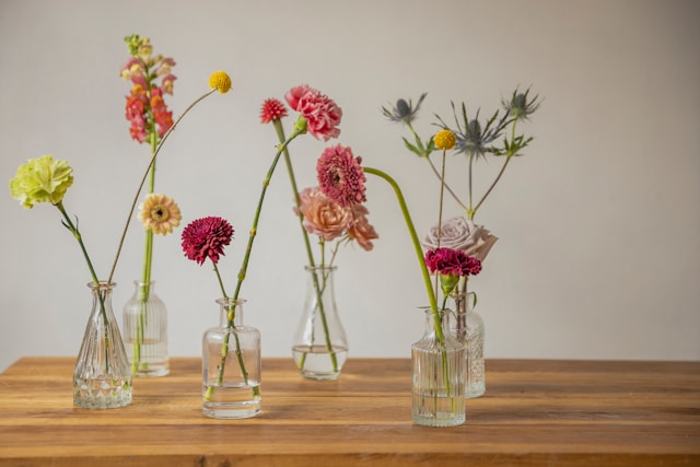 Specimen vases with flowers including carnations and gerberas, Typeset writes case studies for businesses in horticultural and gardening